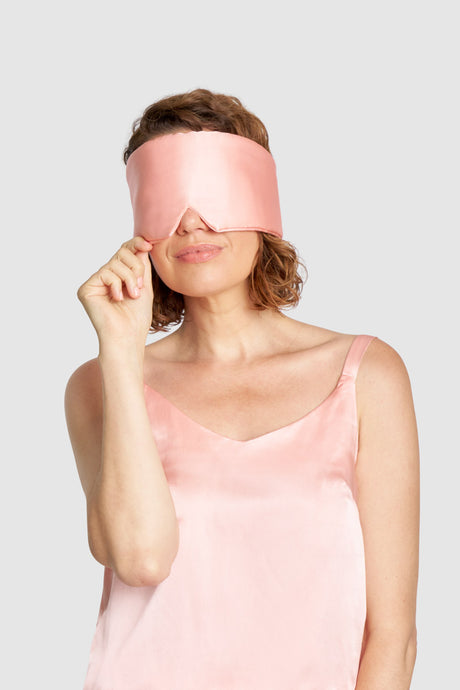 Adjustable sustainable Quartz Pink sleep mask with recycled Velcro® strap, worn by model for restful sleep