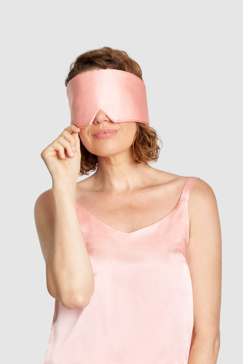 Adjustable sustainable Quartz Pink sleep mask with recycled Velcro® strap, worn by model for restful sleep